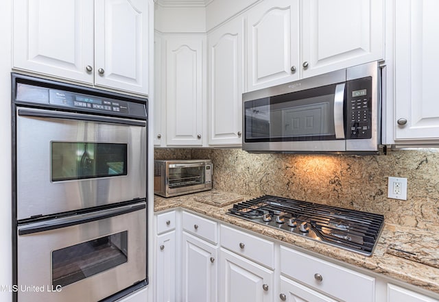 1000 Cedar Hill Rd, Madison, MS 39110 - kitchen with stainless steel appliances, white cabinetry, decorative backsplash, and light stone counters