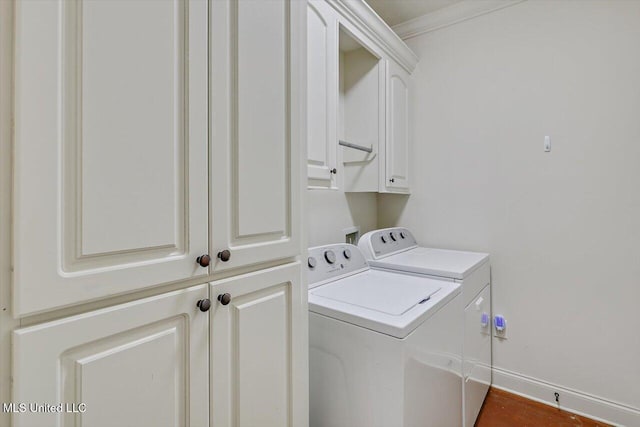 laundry area with cabinets, crown molding, and washer and dryer