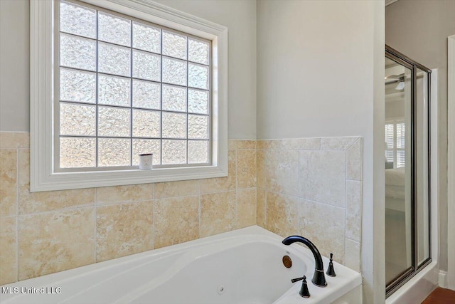 bathroom featuring ceiling fan and independent shower and bath