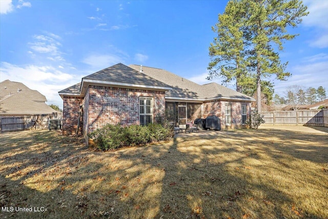 rear view of house with a lawn and central AC unit