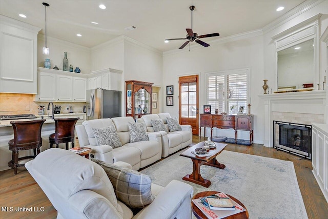 living room with ceiling fan, crown molding, and dark hardwood / wood-style floors