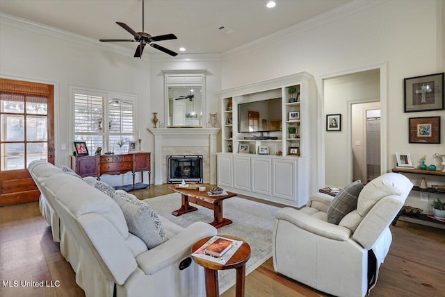 living room with hardwood / wood-style flooring, ceiling fan, and crown molding