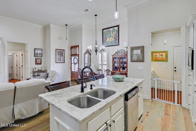 kitchen featuring a kitchen island with sink, sink, decorative light fixtures, an inviting chandelier, and dishwasher