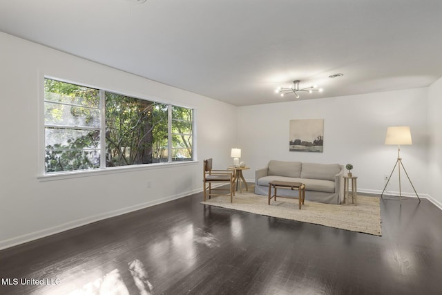 living room with wood finished floors, baseboards, and a chandelier