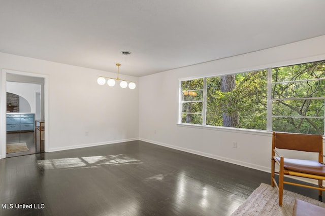 spare room with baseboards and dark wood-type flooring
