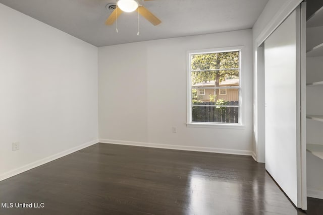 unfurnished bedroom featuring wood finished floors, baseboards, ceiling fan, and a closet