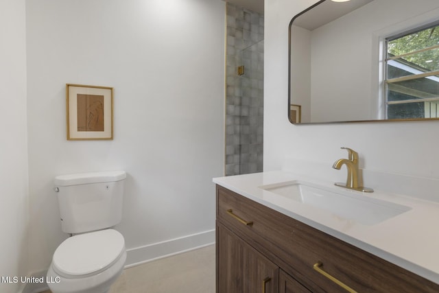 bathroom featuring toilet, vanity, and baseboards