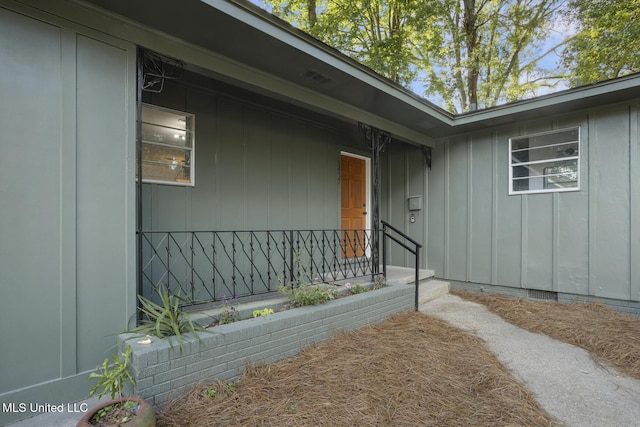 property entrance featuring board and batten siding and crawl space
