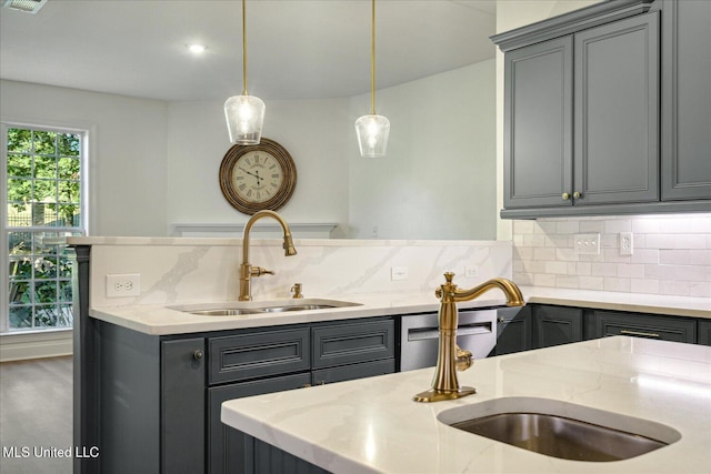 kitchen featuring light stone countertops, sink, and decorative backsplash