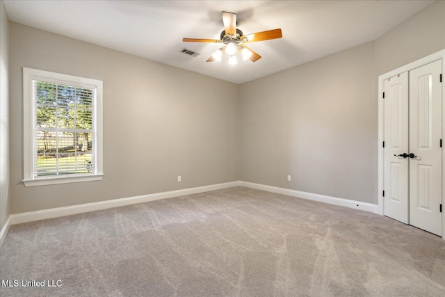 spare room featuring light carpet and ceiling fan