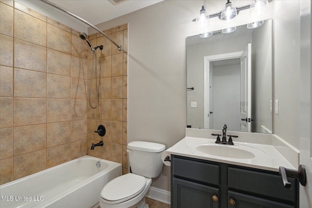 full bathroom featuring vanity, tiled shower / bath combo, and toilet