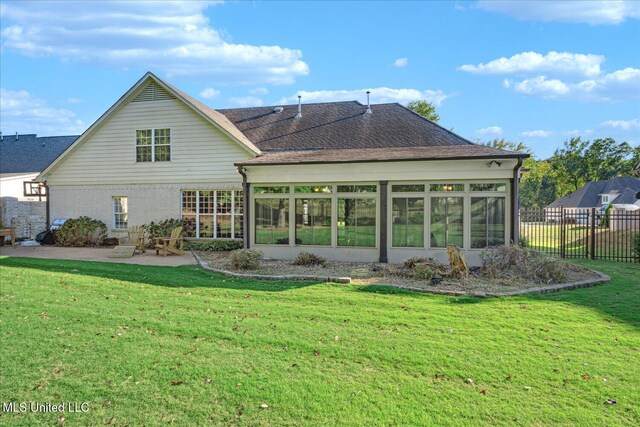 back of property featuring a lawn, a sunroom, and a patio