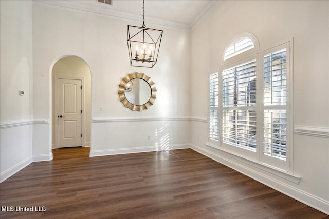 empty room with ornamental molding, dark hardwood / wood-style floors, and a notable chandelier