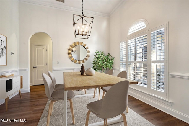 dining area with dark hardwood / wood-style flooring, crown molding, a chandelier, and a healthy amount of sunlight