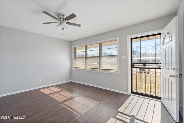 empty room with ceiling fan and dark hardwood / wood-style floors