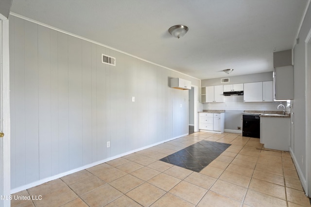 kitchen with sink, white cabinets, black dishwasher, light tile patterned flooring, and tasteful backsplash