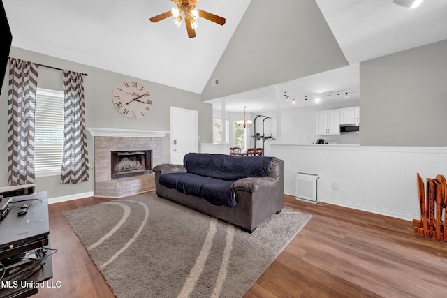 8968 Tahoe Cv, Olive Branch, MS 38654 - living room featuring ceiling fan, wood finished floors, a fireplace, vaulted ceiling, and wainscoting