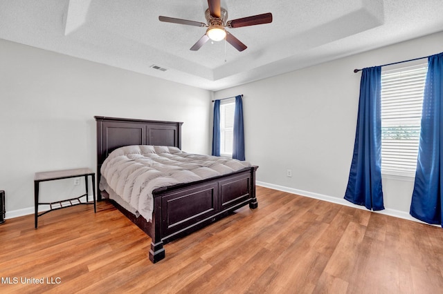 8968 Tahoe Cv, Olive Branch, MS 38654 - bedroom with a tray ceiling, light wood-style flooring, a textured ceiling, and ceiling fan