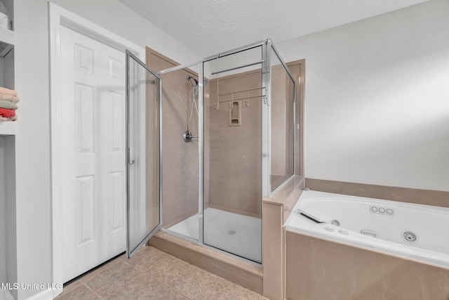 8968 Tahoe Cv, Olive Branch, MS 38654 - full bathroom featuring a shower stall, a jetted tub, tile patterned floors, and a textured ceiling