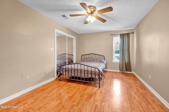8968 Tahoe Cv, Olive Branch, MS 38654 - bedroom with light wood-style floors, a textured ceiling, a ceiling fan, and a closet