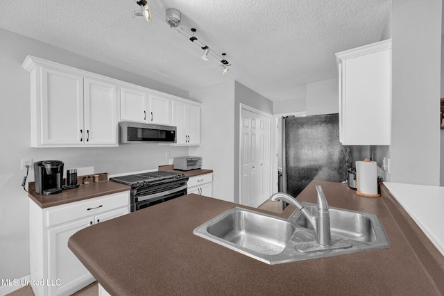 8968 Tahoe Cv, Olive Branch, MS 38654 - kitchen with black range, stainless steel microwave, dark countertops, a textured ceiling, and white cabinets