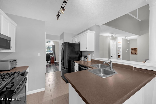 8968 Tahoe Cv, Olive Branch, MS 38654 - kitchen featuring black appliances, rail lighting, dark countertops, light tile patterned floors, and white cabinetry