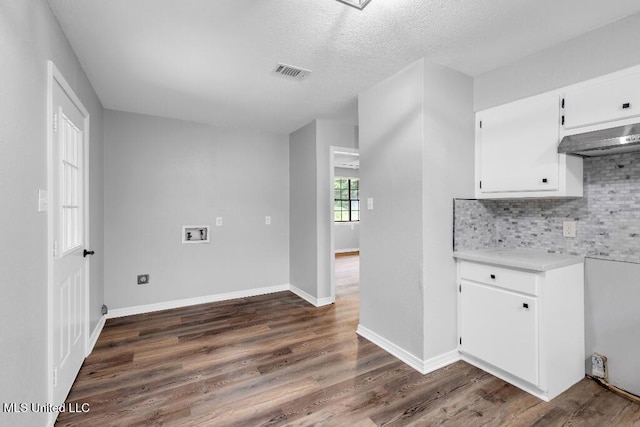 29 Summer Ln, Poplarville, MS 39470 - kitchen with light countertops, backsplash, dark wood finished floors, white cabinets, and wall chimney exhaust hood