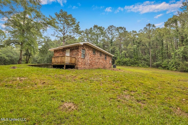 29 Summer Ln, Poplarville, MS 39470 - view of home's exterior with a yard, a deck, a forest view, and brick siding