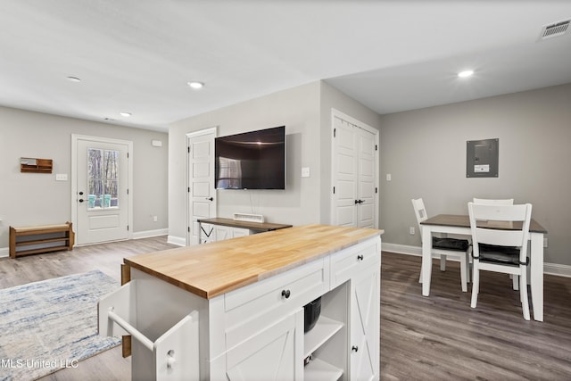 kitchen featuring butcher block counters, light hardwood / wood-style floors, white cabinets, and a kitchen island