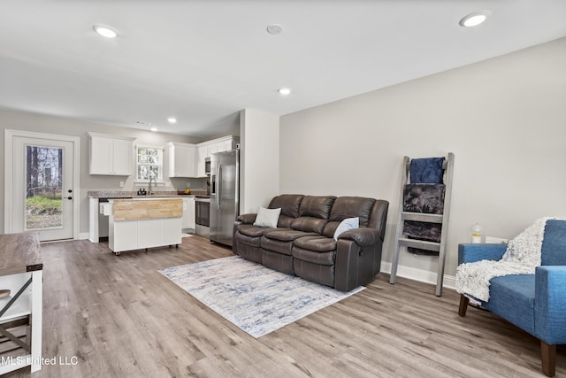 living room featuring sink and light hardwood / wood-style floors