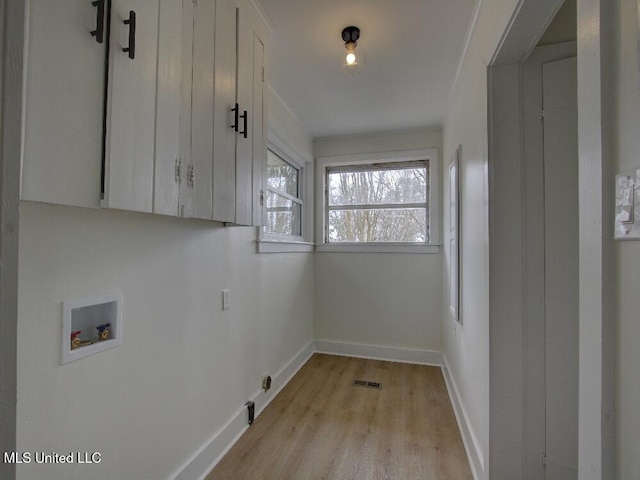 laundry room featuring washer hookup, visible vents, light wood-style floors, baseboards, and cabinet space