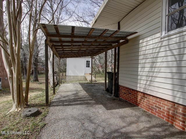 view of parking / parking lot featuring a detached carport and driveway