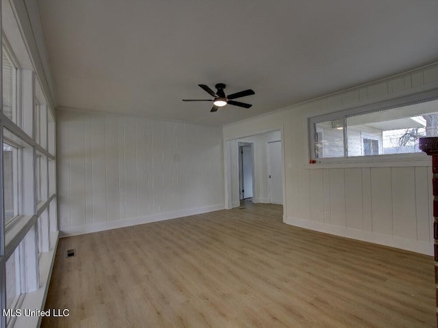 unfurnished room with baseboards, ceiling fan, visible vents, and wood finished floors