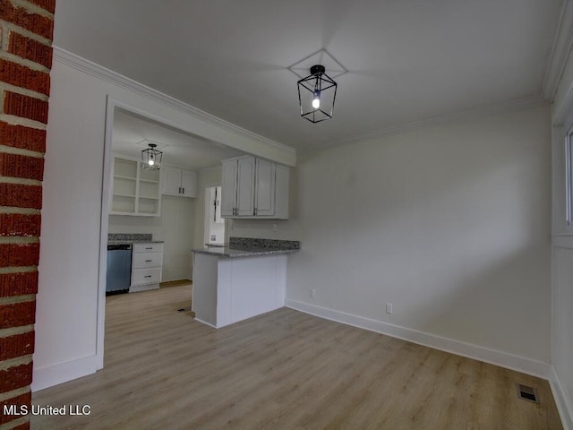 kitchen with baseboards, light wood-style flooring, a peninsula, crown molding, and stainless steel dishwasher