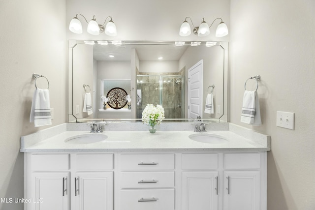 bathroom featuring a shower with shower door and vanity