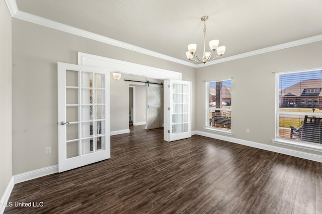 unfurnished dining area with dark wood-type flooring, crown molding, a notable chandelier, and a barn door