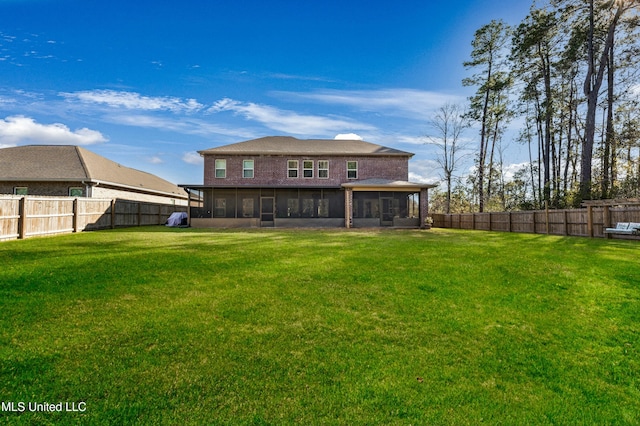 back of house featuring a yard and a sunroom