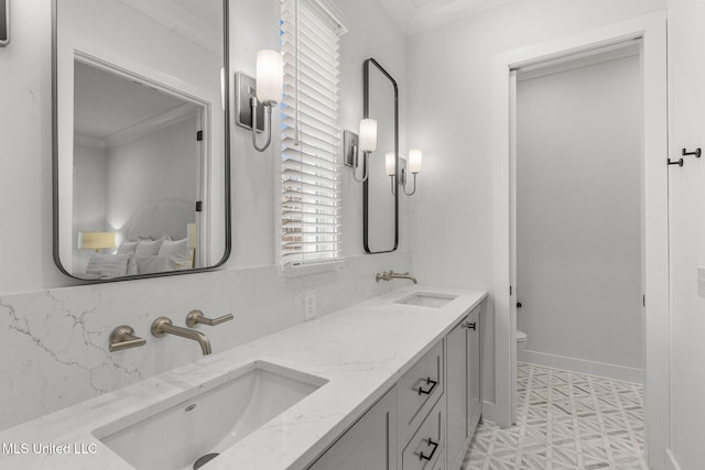 bathroom featuring vanity, a healthy amount of sunlight, toilet, and crown molding