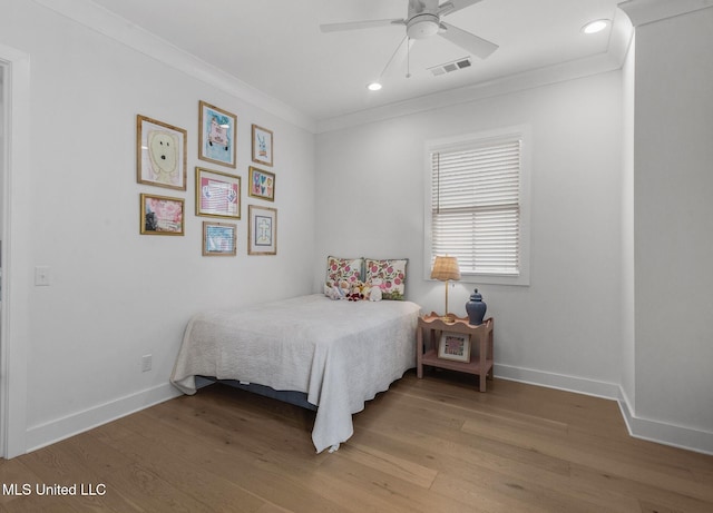 bedroom featuring light wood-type flooring, ceiling fan, and crown molding