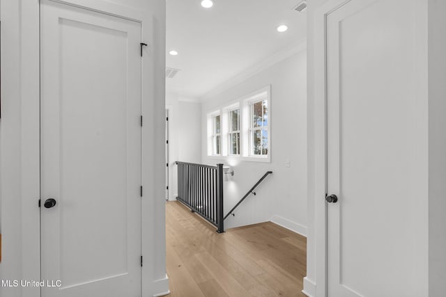 corridor with crown molding and light hardwood / wood-style flooring