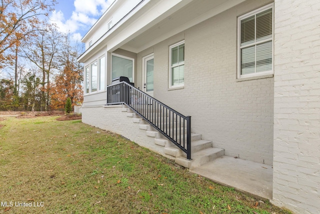 doorway to property featuring a lawn