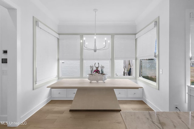 bathroom with crown molding, breakfast area, an inviting chandelier, and hardwood / wood-style flooring