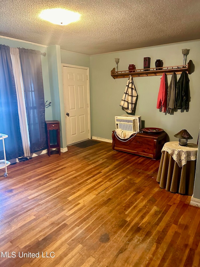2236 Long St, Grenada, MS 38901 - unfurnished bedroom with hardwood / wood-style flooring, a textured ceiling, and a wall mounted air conditioner