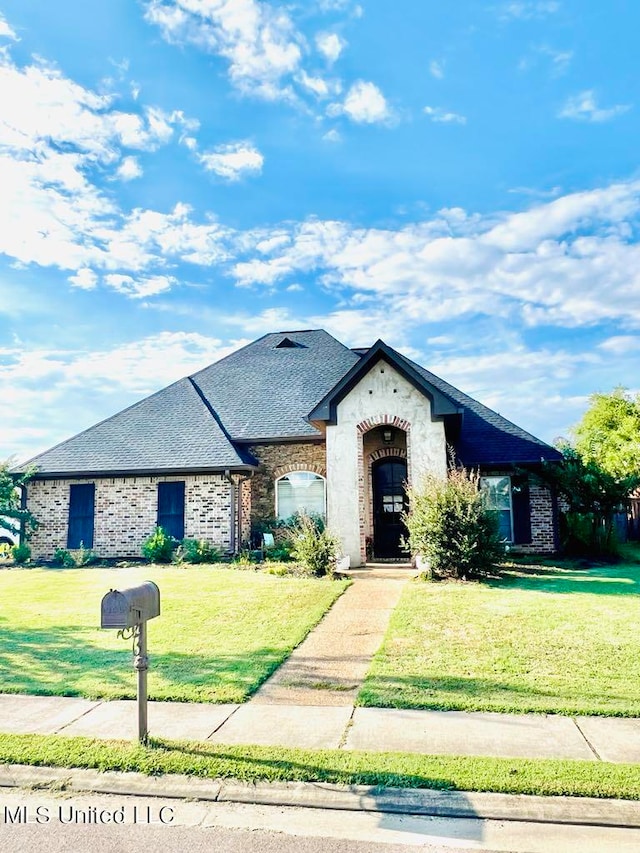 french provincial home featuring a front yard