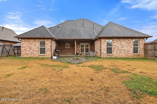 rear view of property with a gazebo, a yard, and a fire pit