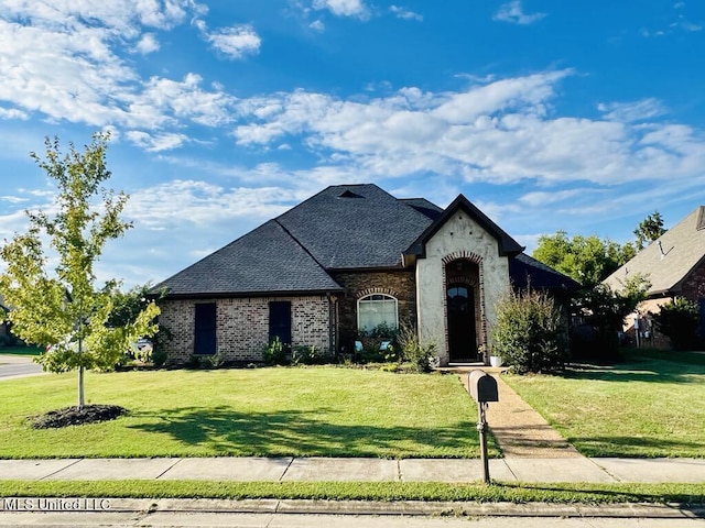 french country home featuring a front lawn