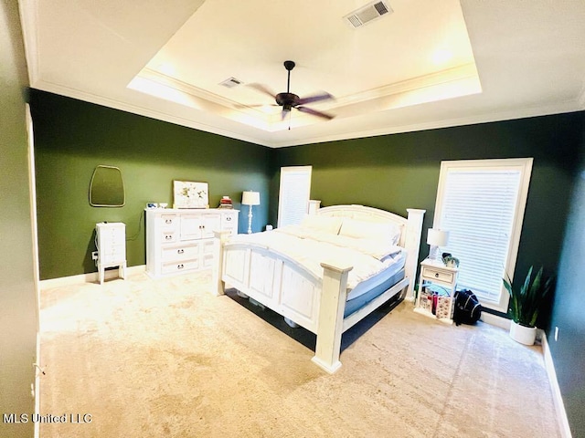 bedroom with light colored carpet, a raised ceiling, ceiling fan, and crown molding