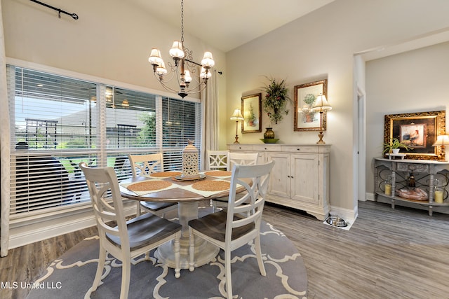 dining space with a chandelier, wood finished floors, healthy amount of natural light, baseboards, and vaulted ceiling