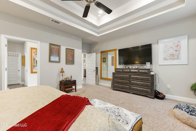 bedroom with a raised ceiling, crown molding, baseboards, carpet floors, and ensuite bathroom