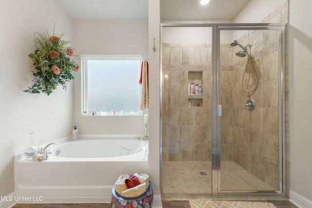 full bath with a stall shower, a bath, and baseboards